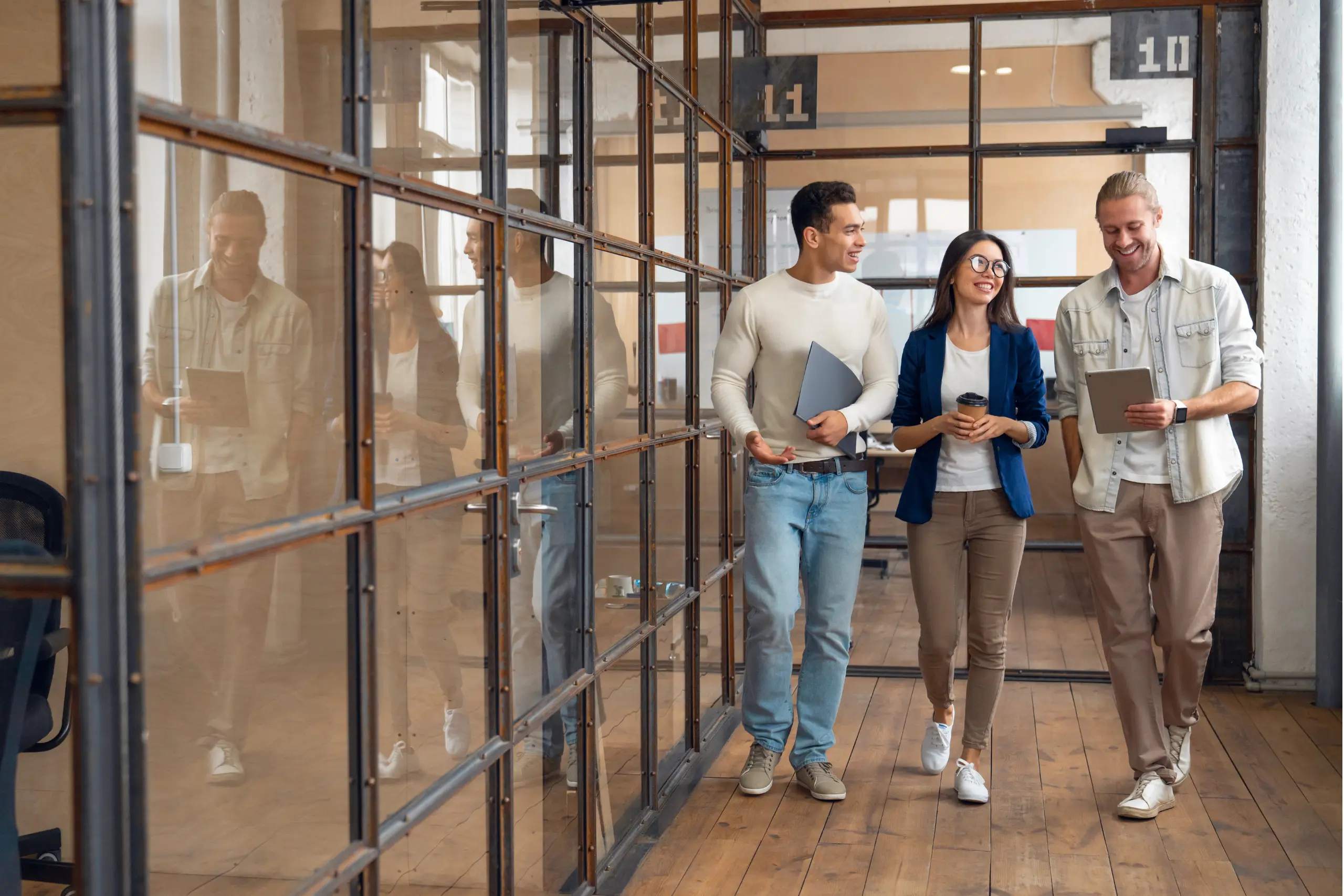 Three young adults walking and talking in the office