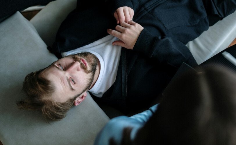 A hand holding a compass pointed toward light